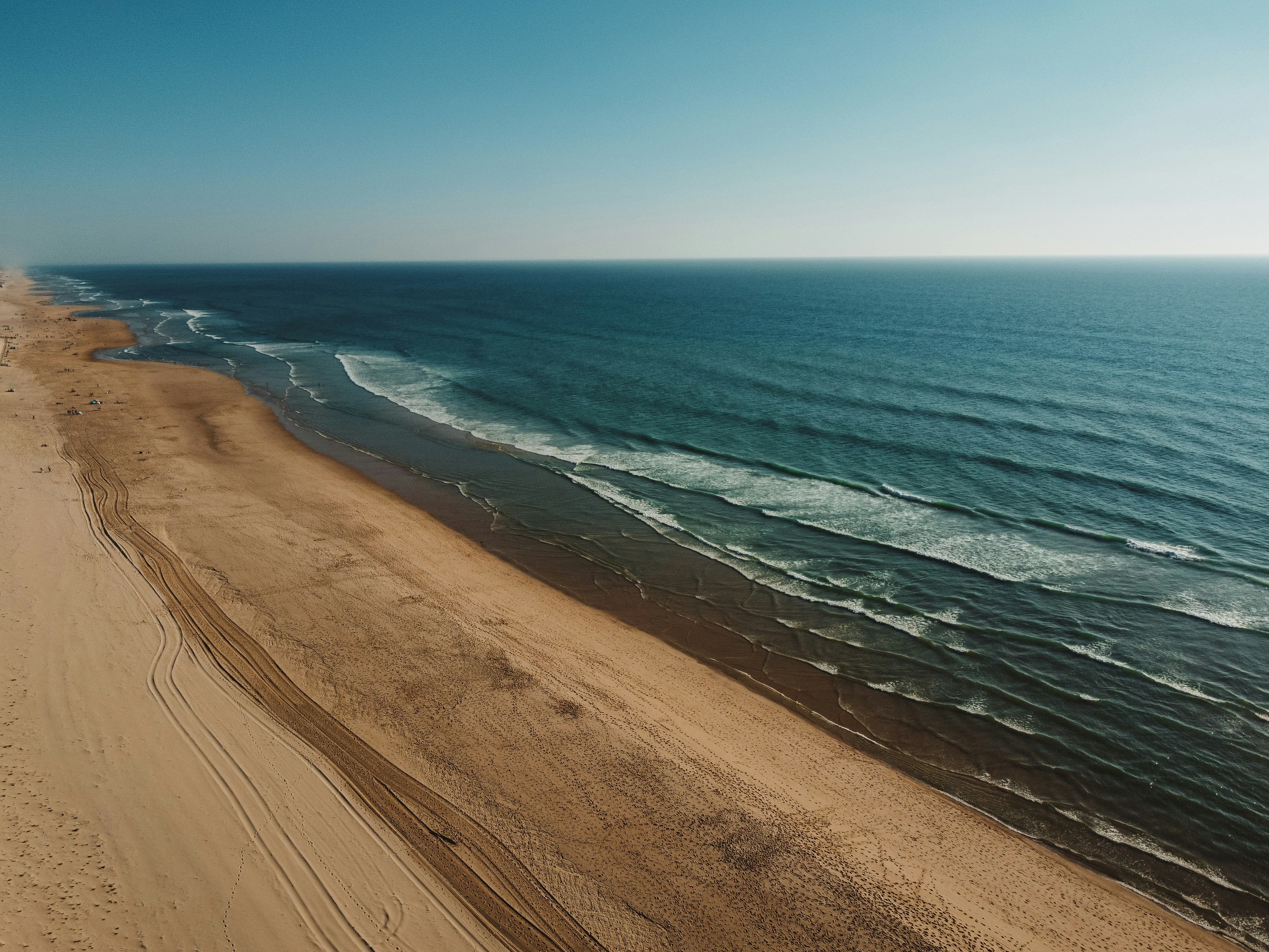 brown sand near body of water during daytime